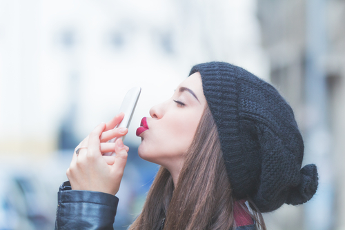 ケータイにキスする女性